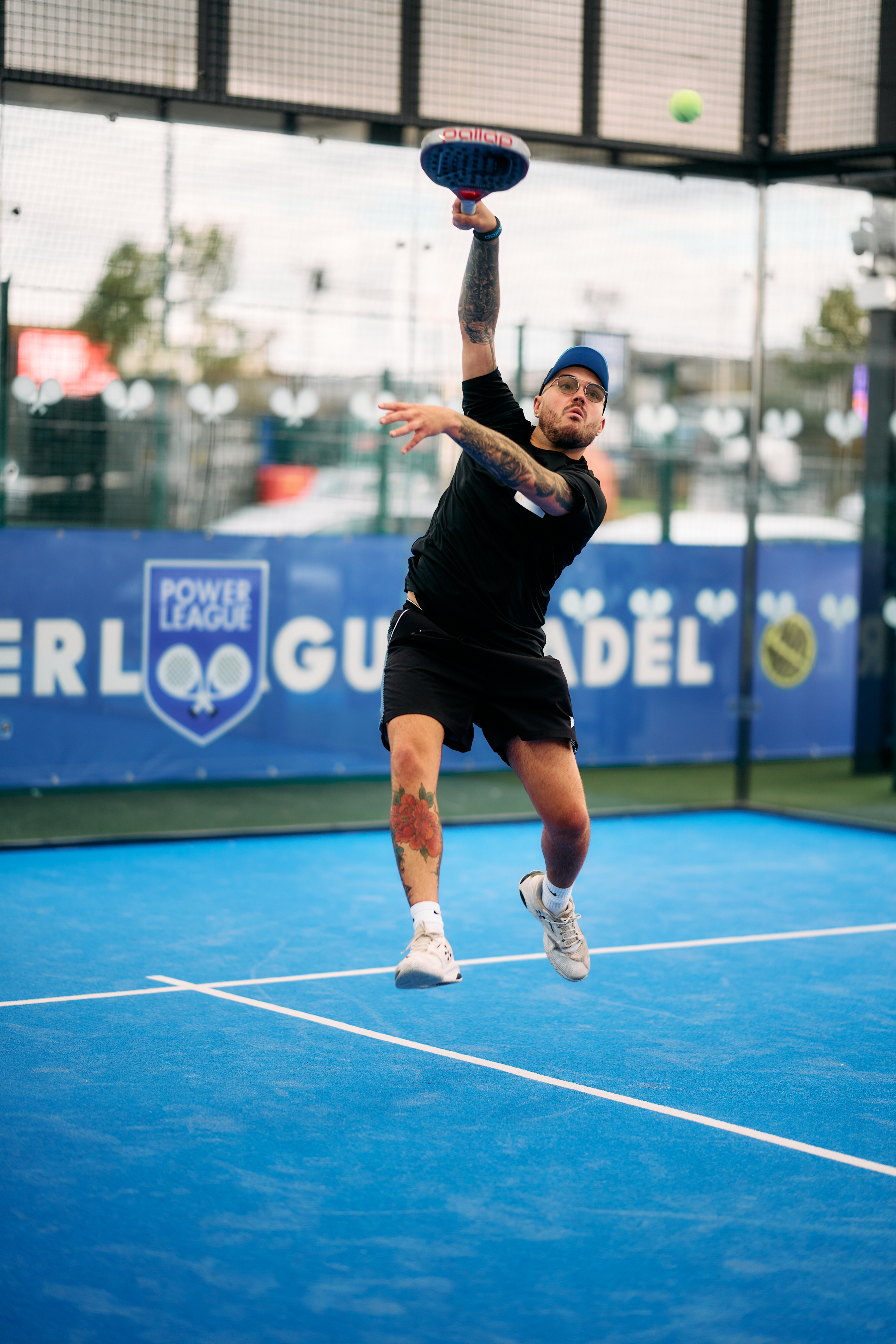 Player in a cap leaping to smash the ball