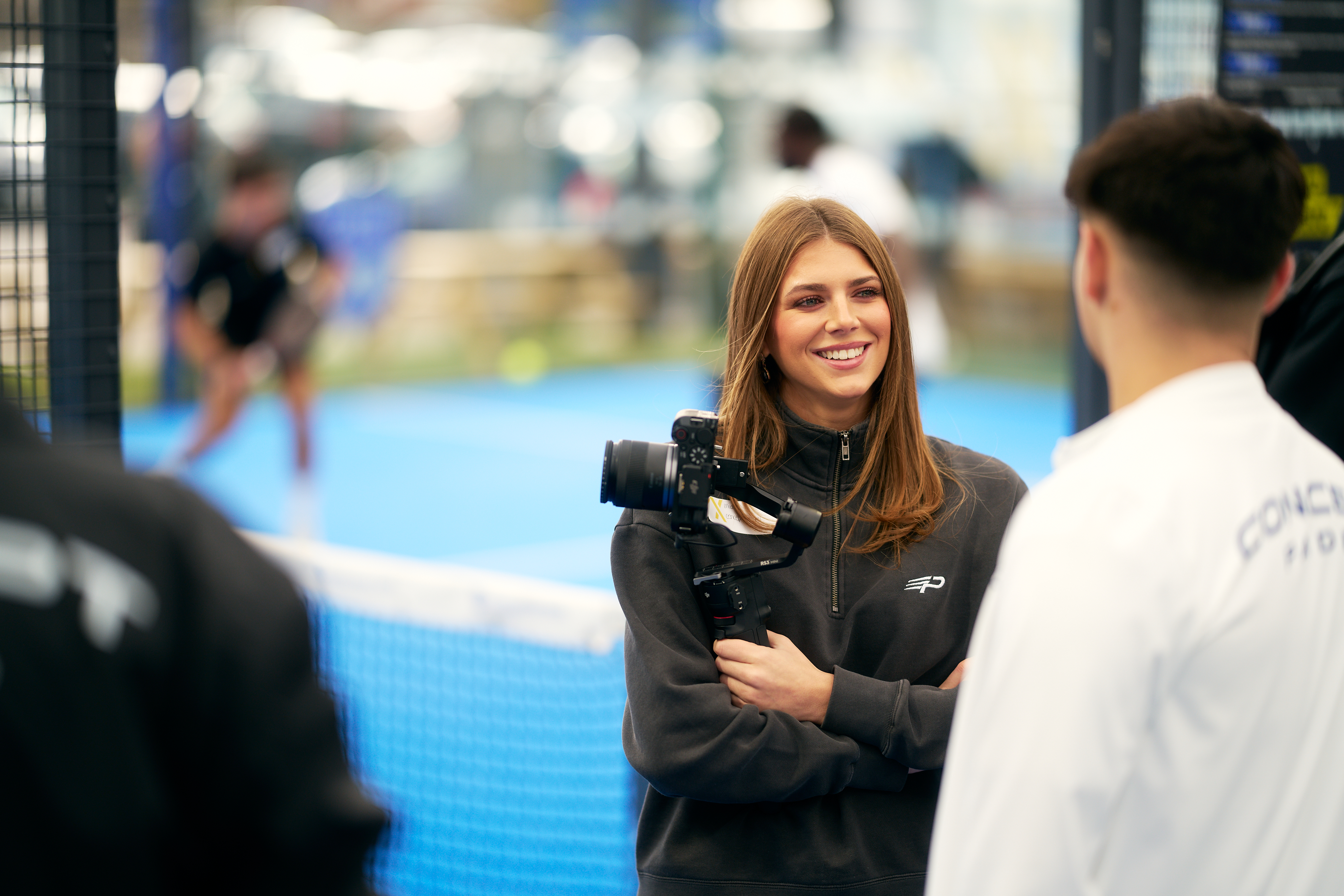 Content creator with a camera chatting to guests courtside