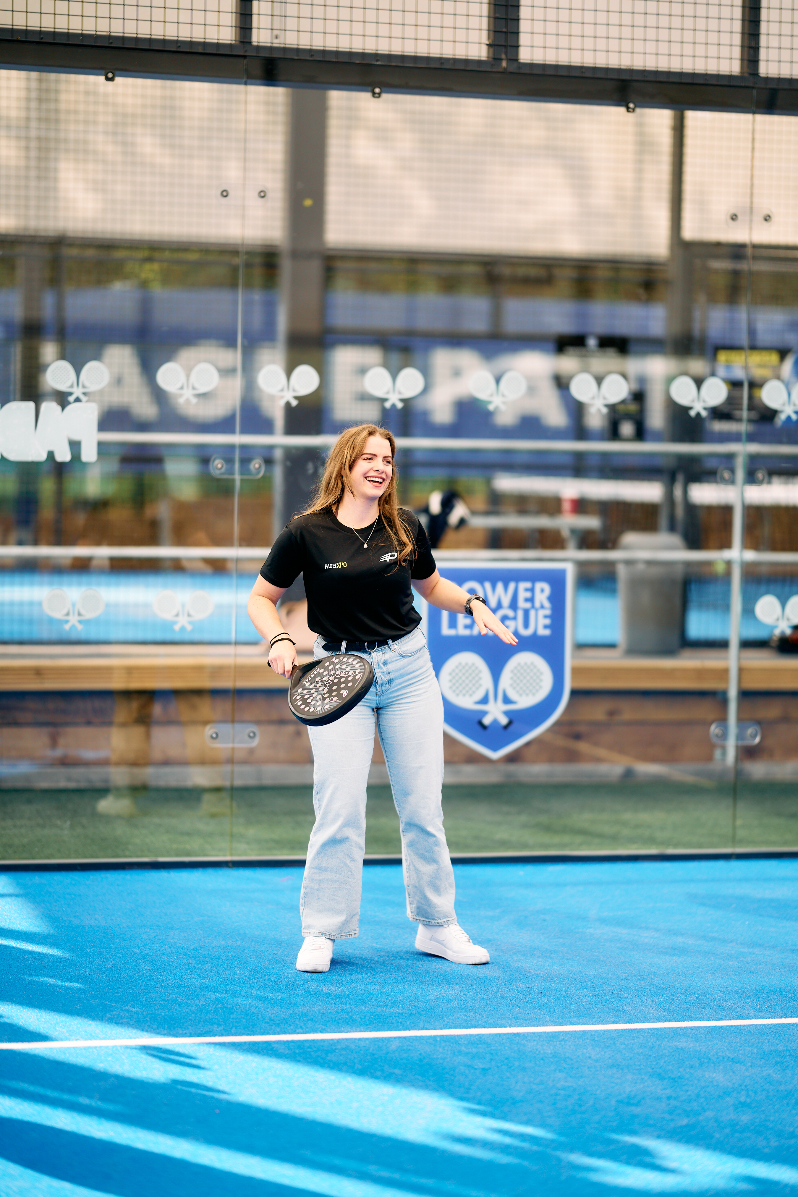 Guest laughing while trying padel for the first time