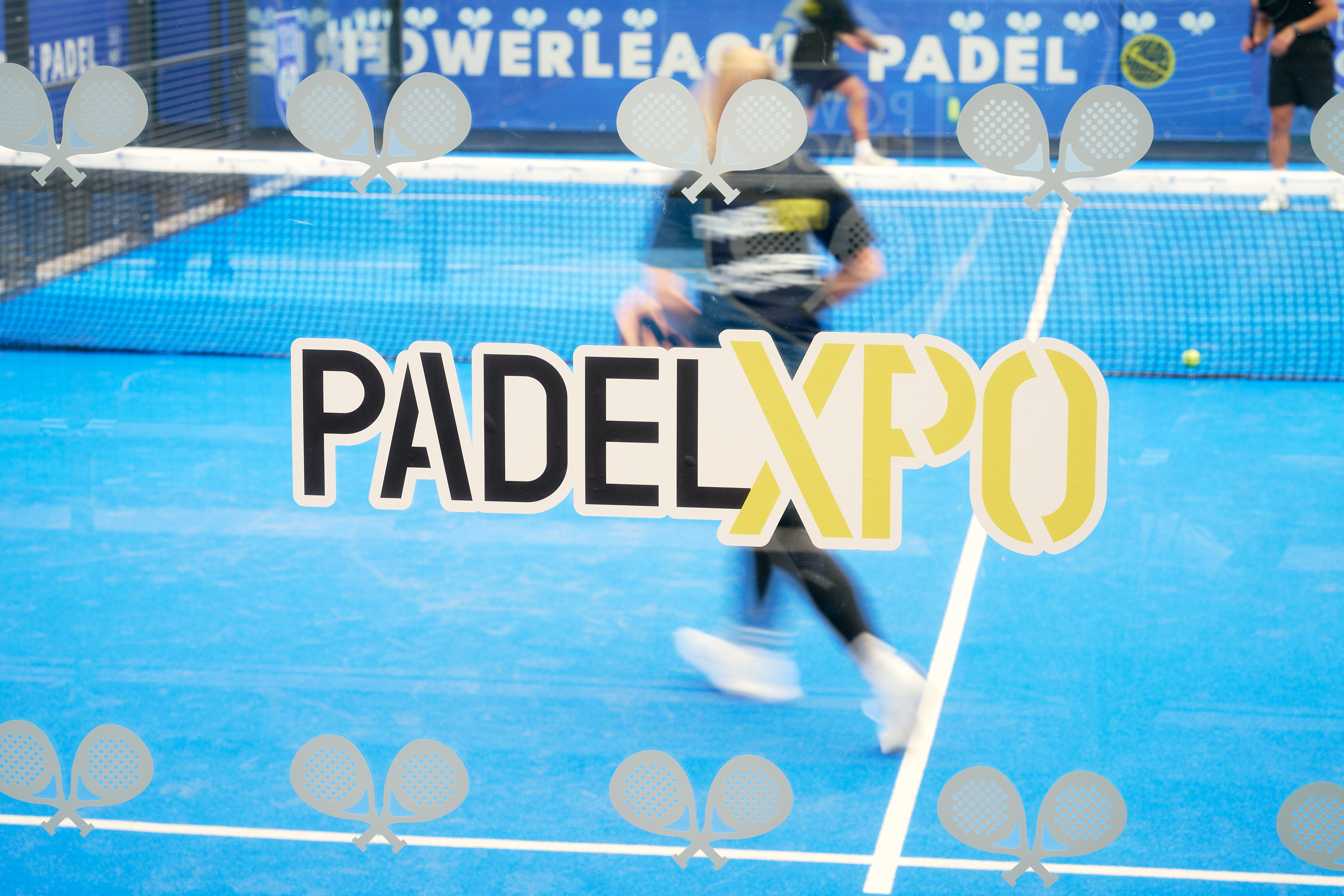 PadelXPO logo on the court glass with a player in motion behind