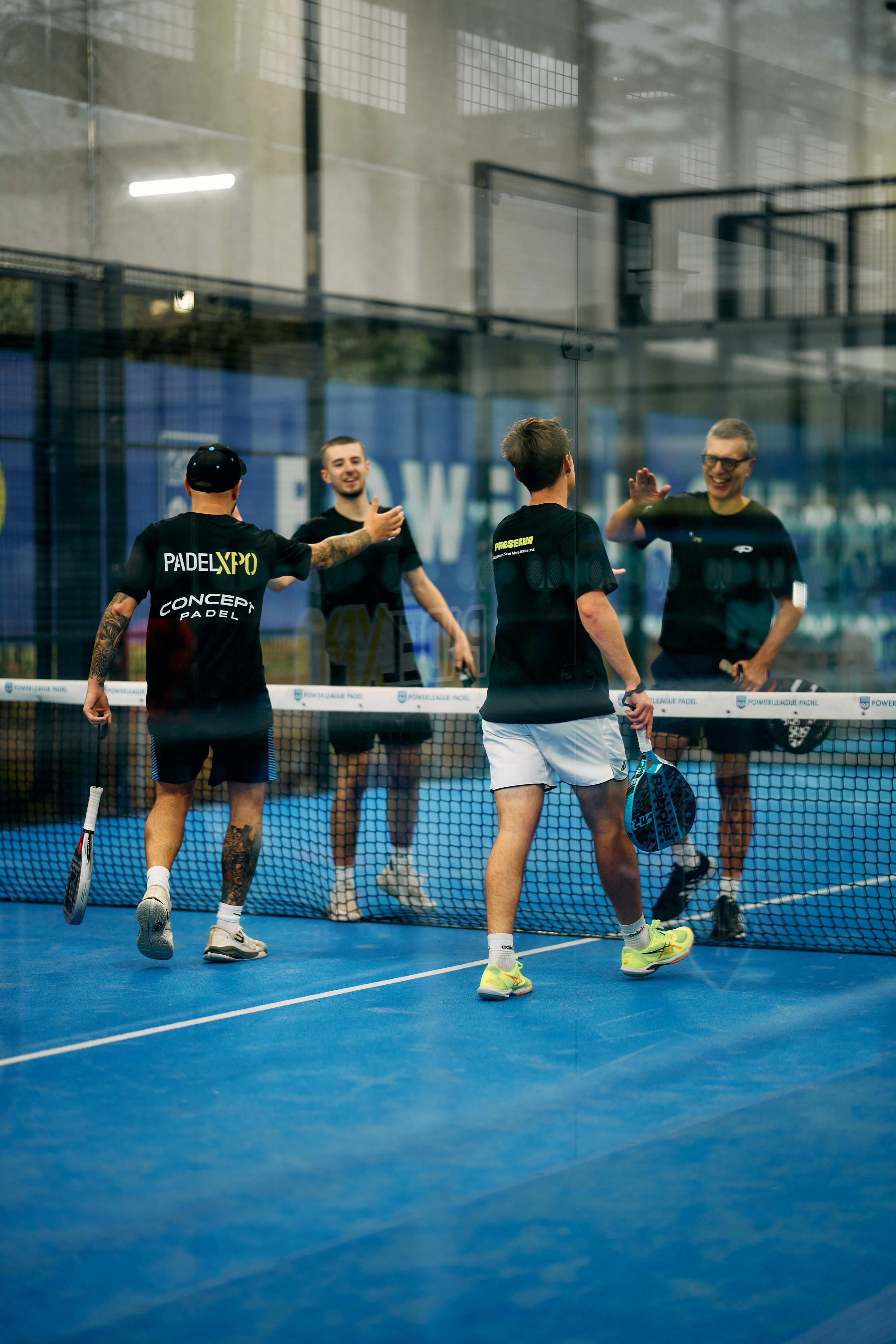 Players high-fiving across the net after a match